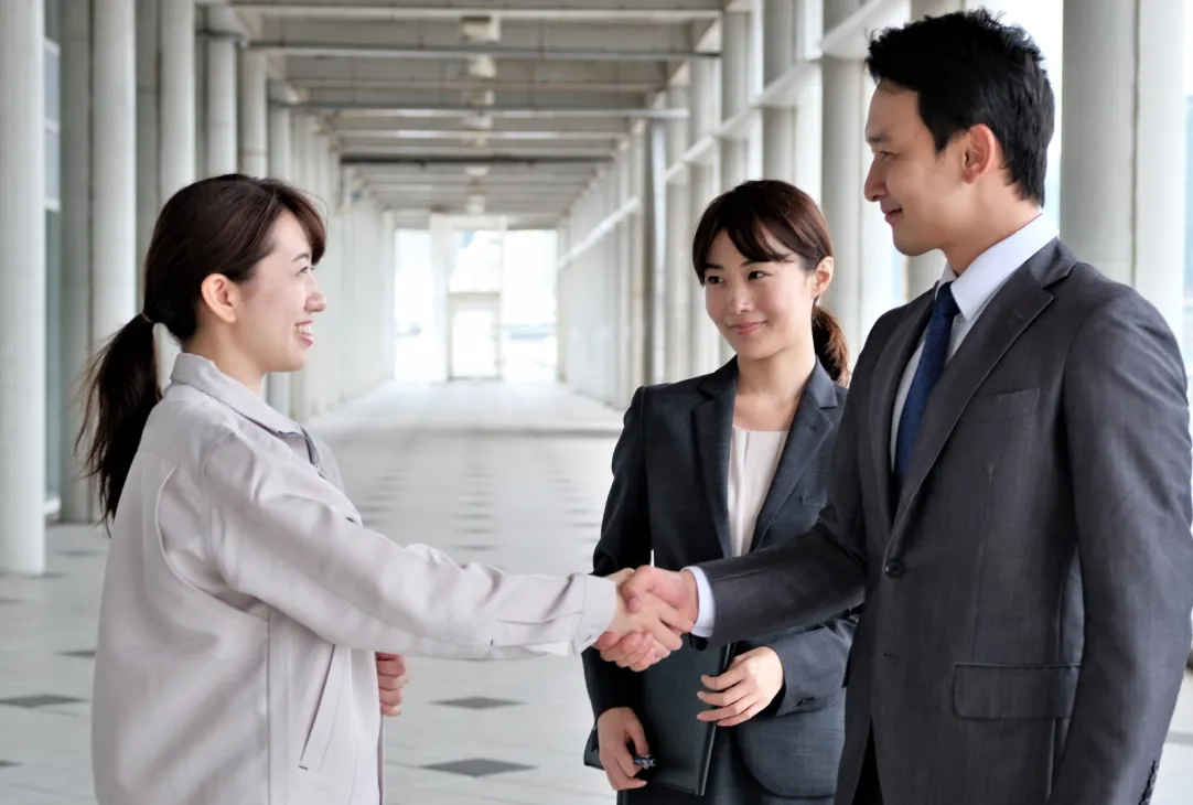 コンサルタントと握手をする工場の女性社員