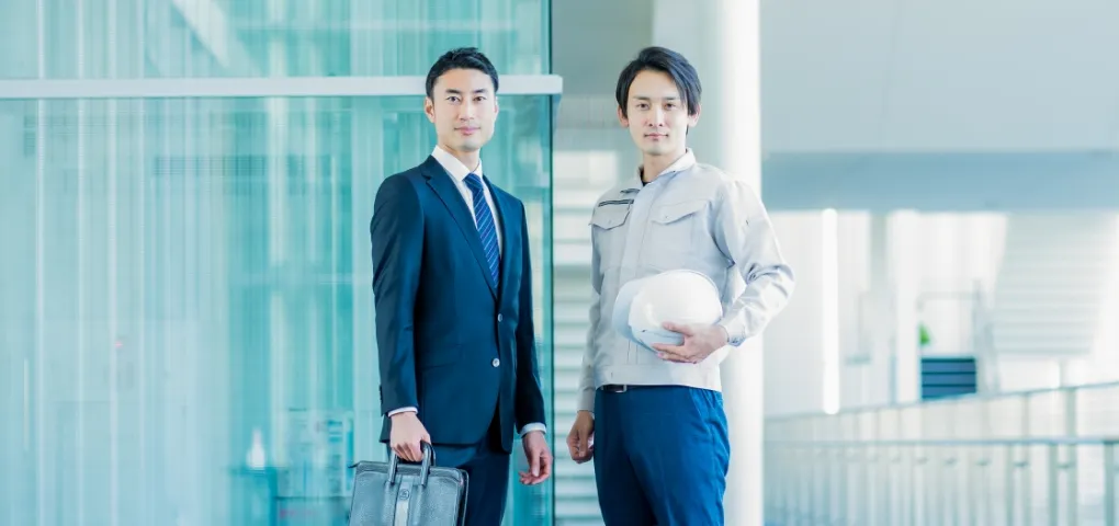 工場で働く人と握手をするコンサルタントのイメージ